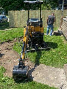 S3E 1-ton excavator on grass near a wooden fence