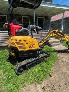 S3E 1-ton excavator on grass in front of a house