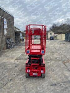S3E red scissor lift on a concrete lot with industrial buildings