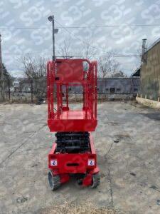 S3E red scissor lift on a concrete lot with industrial background
