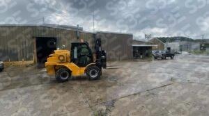 S3E yellow forklift on a wet concrete lot in front of a warehouse